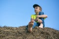 The boy on the haystack. Bare feet. Blue sky. Summer day