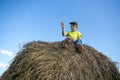 The boy on the haystack. Bare feet. Blue sky. Summer day