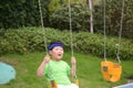 A boy with a headband have a ride on a swing Royalty Free Stock Photo