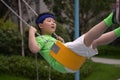 A boy with a headband have a ride on a swing Royalty Free Stock Photo