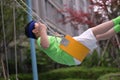 A boy with a headband have a ride on a swing Royalty Free Stock Photo