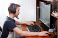 A boy in headphones in front of a computer does his homework. Distance learning in quarantine Royalty Free Stock Photo