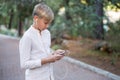 Boy with headphones, phone and tablet walks in the city and park