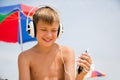 Boy with headphones using a smartphone on the beach Royalty Free Stock Photo
