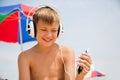 Boy with headphones using a smartphone on the beach