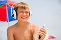 Boy with headphones using a smartphone on the beach Royalty Free Stock Photo