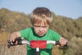 A boy in a helmet with a backpack rides a bicycle. Walk in the park concept of moving forward, achieving success Royalty Free Stock Photo