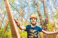 A boy in a helmet on a cable car in the forest overcomes obstacles