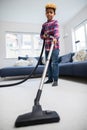 Boy Helping Out With Chores At Home Vacuuming Carpet In Lounge