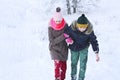 The boy helps the girl to climb out of the snow and move on
