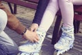 Boy helps the girl to wear roller skates. Royalty Free Stock Photo