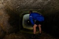 Boy hiker - mountainbiker in a sabdstone cave or dry water channel. Visiting of underground Royalty Free Stock Photo