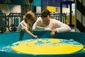 Boy and his father are enthusiastically playing with colored kinetic sand in game center. Sand therapy. Creativity and relaxation