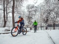A boy and his father ride bicycles in a winter park