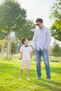 The boy and his father stand in the Park on the green grass and look at each other