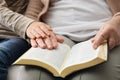 Boy and his godparent reading Bible together, closeup