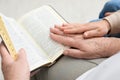 Boy and his godparent reading Bible together indoors, closeup