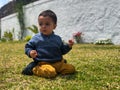 boy on his knees in the garden looking down enjoying the sunny day