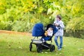 Boy with his little siblings in double hogger stroller Royalty Free Stock Photo