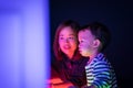 A boy and his mom are playing colorful light cubes.