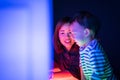 A boy and his mom are playing colorful light cubes.