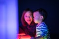 A boy and his mom are playing colorful light cubes.