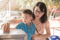 Boy and his mother all toghter donate by put money in donation box. Royalty Free Stock Photo