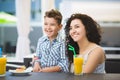 Boy and his mother tasting dessert with juice in resort restaurant outdoor