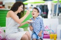 Boy and his mother tasting dessert with juice in resort restaurant outdoor