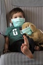 Boy and his stuffed puppy in protection masks Royalty Free Stock Photo