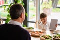 A boy with his tablet sitting at the dinner table Royalty Free Stock Photo