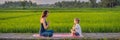 Boy and his yoga teacher doing yoga in a rice field BANNER, LONG FORMAT