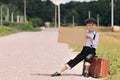 Boy hitch hiking on the road Royalty Free Stock Photo