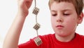 Boy hold chain compound of magnet spheres cubic