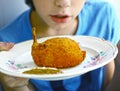 Boy hold chicken kiev with bone on the plate Royalty Free Stock Photo