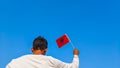Boy holding Albania flag against clear blue sky. Man hand waving Albanian flag view from back, copy space