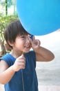 Boy holding balloon with victory hand sign