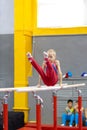 boy holding on bars, gymnast exercise parallel bars in championship gymnastics