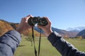 Boy holding binoculars in beautiful mountains on sunny day, closeup Royalty Free Stock Photo