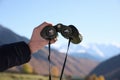 Boy holding binoculars in beautiful mountains on sunny day, closeup Royalty Free Stock Photo