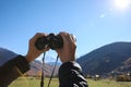 Boy holding binoculars in beautiful mountains on sunny day, closeup Royalty Free Stock Photo