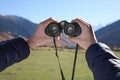 Boy holding binoculars in beautiful mountains on sunny day, closeup Royalty Free Stock Photo