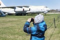 Boy holding camera and taking photos of old decommisioned planes Royalty Free Stock Photo