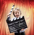 Boy holding a clapper board in a cinema theater Royalty Free Stock Photo