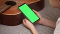 Boy holding and clicks the smartphone with green screen