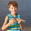 Boy holding fish and smiling Royalty Free Stock Photo