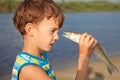 Boy holding fish and smiling Royalty Free Stock Photo
