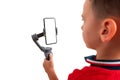 Boy holding gimbal with smart phone in vertical position. Isoalted background and display for mockup