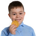 Boy holding a gingerbread in the form of a dollar coin in his hand, as if trying it, the concept of financing