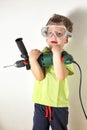 Boy holding heavy drilling machine in his arms